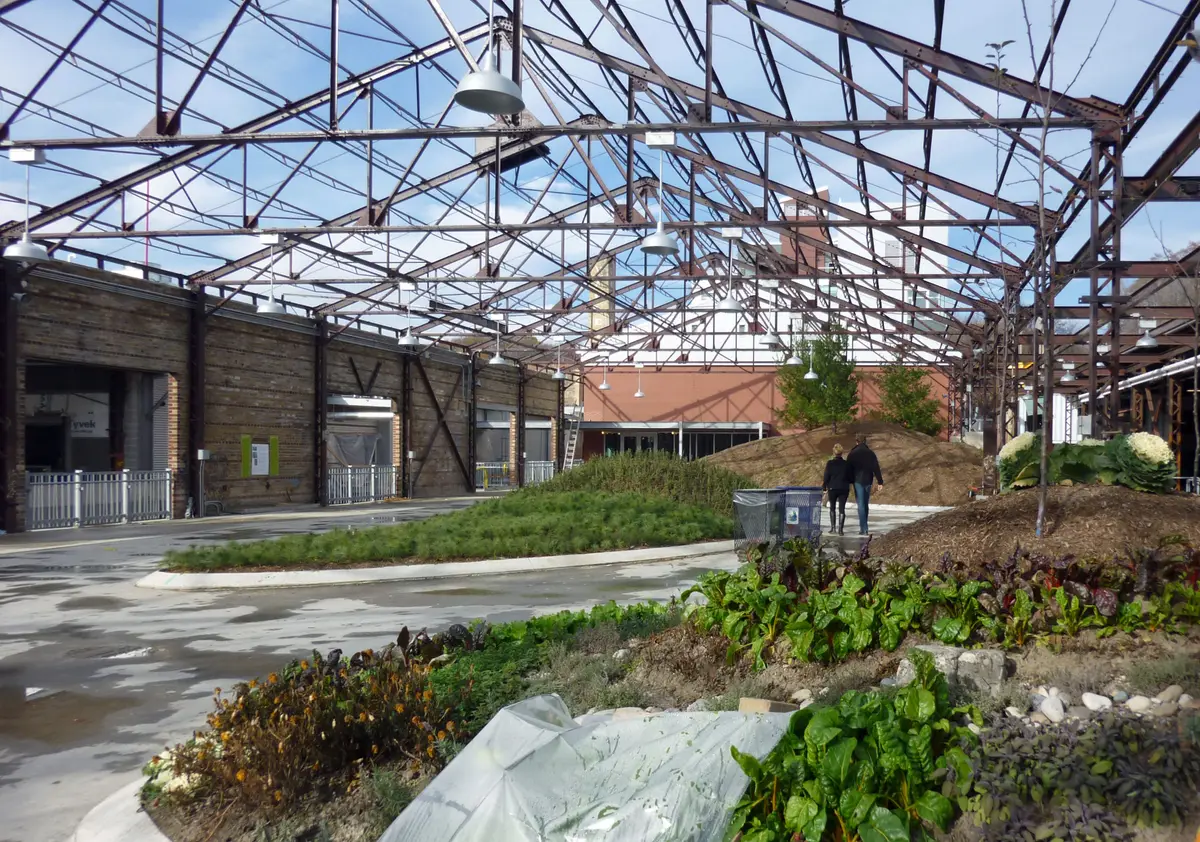 Snow patches and a steel-truss shed roof at the Don Valley Brick Works in January, with two visitors in the distance